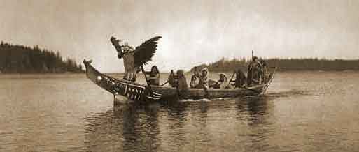Coming for the Bride, photo by Edward Curtis 1914, [public domain]: In the bow qunhulahl, a masked man personating the thunderbird, dances as others row to the shores of the bride's village